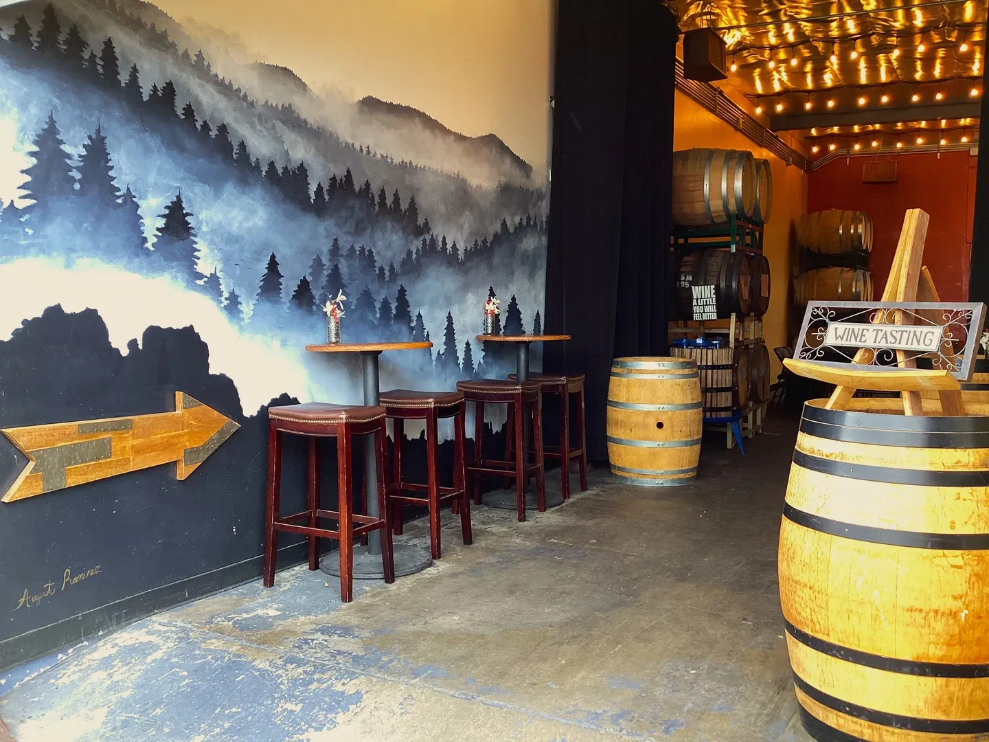 A room with a wall mural and barrels